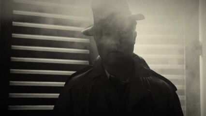 Man standing in smoke filled room in front of window blinds in black white