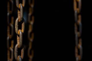 Old rusty chains on dark background with selective focus and copy space.