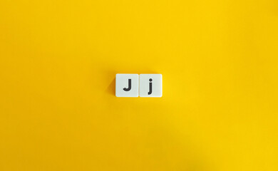 Capital and Small Letter J. Uppercase and Lowercase Letter. Concept of Learning Alphabet. Text on Block Letter Tiles against Yellow Orange Background