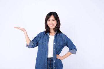 Asian woman wearing denim jean is gesturing with her hand to showing a product against a white...
