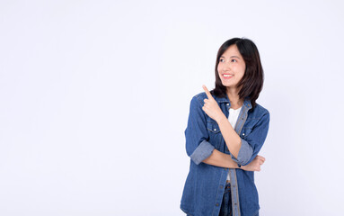A young asian woman wearing denim jean while pointing finger to free copy space isolated on white...
