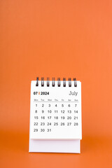 Vertical of July 2024 table calendar on orange background.