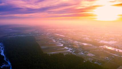 Spring rural landscape. Countryside in the evening. Aerial view. Panoramic view of village, fields, pine forest, and river during sunset