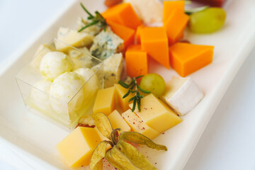 Plate with assorted cheeses and sauce. Appetizer for the buffet. Banquet menu for the holiday.