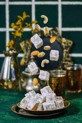 flying traditional Turkish delight (lokum) with nuts and arabic tea, gypsophila vase
