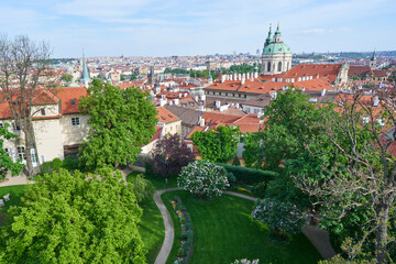 Panoramatic picture of the old town of Prague taken from the hill of Prague castle in sunny spring day. Beautiful part of the city Lesser town with many historic buiding and church of Saint Nicolas.