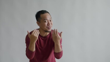 Attractive Asian Man Greet Warmth Welcoming and Inviting to Come With Hand Isolated on Gray Background