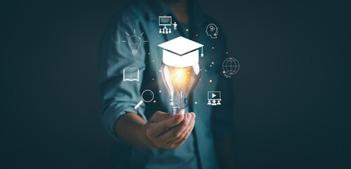 Online education course or e-learning technology Concept.Man holding light bulb on virtual screen...