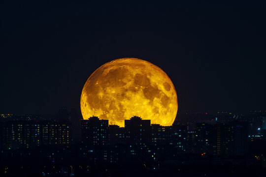 Huge full moon at night with lights from city view - Powered by Adobe