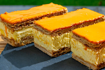 Celebration of the King birthday in Netherlands, tompoes or tompouce, iconic pastry in Netherlands made from puff dough, orange icing, cream