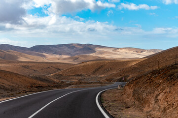 Mountain road on colourful remote basal hills and mountains of Massif of Betancuria, Fuerteventura, Canary islands, Spain
