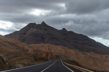 Mountain road on colourful remote basal hills and mountains of Massif of Betancuria, Fuerteventura, Canary islands, Spain