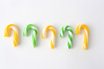 Christmas candies in yellow and green on a white background. New Year concept.Candies in the form...