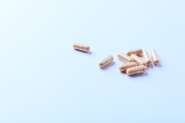 Lutein capsules. Dietary supplement on bright paper background. Soft focus. Close up. Copy space.