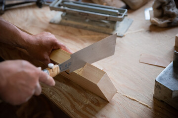 ノコギリを使って作業をする大工