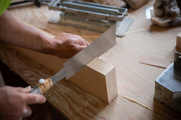 ノコギリを使って作業をする大工