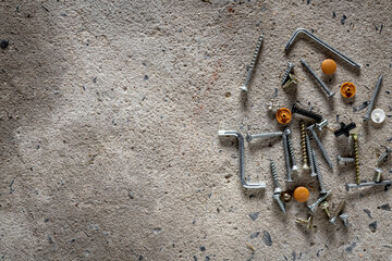 Screw, nail on concrete texture background. Closeup of screws and nails on cement floor, copy space.