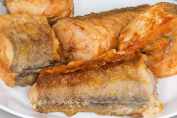 Fried hake pieces on dish close-up in selective focus