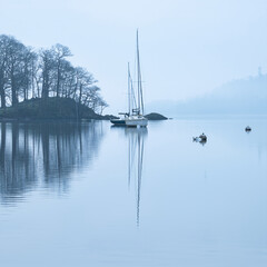 Stunning peaceful landscape image of misty Spring morning over Windermere in Lake District and...