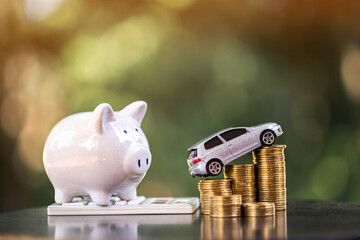 Piggy bank and car model put on the stacked gold coin and calculator with growing interest in the...