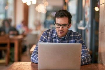 Businessman, laptop and remote work in coffee shop for online research, communication and networking. Male freelance writer, technology and connection for social media and ideas for contact in cafe