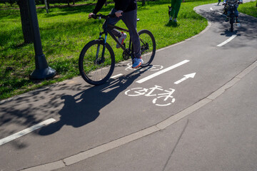 Cycle Walk. Unrecognisable cyclists riding along the cycleway. A winding cycle path with pictograms...