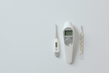 Comparison of mercury thermometer, infrared and electronic thermometer baby thermometer for measuring human body temperature on light background. Types of thermometers. Copy space