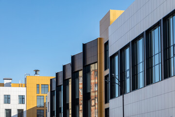 Complex of buildings of different storeys. Ventilated facades in different colours with large...