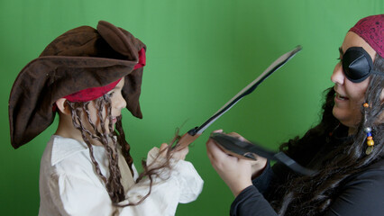 Pirate game. Mom and son having fight with fake cutlasses. Halloween activity. High quality photo