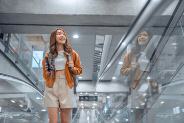 Happy attractive asian woman traveler with backpack at the modern airport terminal, copy space, Tourist journey trip concept