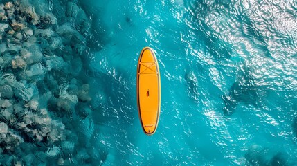 An aerial view of a person on a yellow stand-up paddleboard in the ocean.