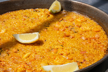 The Spanish national dish paella is ready to eat in a large frying pan.