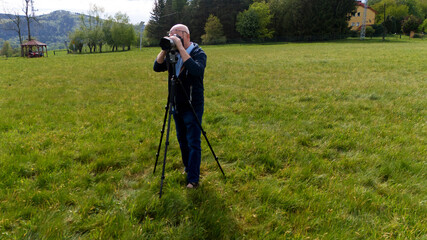 Fotograf robi zdjęcia aparatem fotograficznym na statywie.