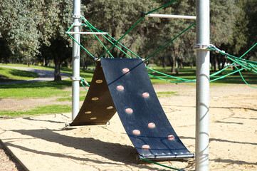 Green rope net and climbing ramp of the playground. Early childhood concept and children's playground.