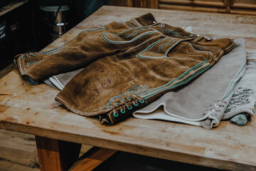 Making and sewing traditional Bavarian shorts. Lederhosen lie on the tailor's table.