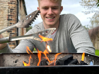 Selective focus on fire flames, cheerful handsome man smiling on background