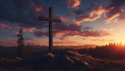 A wooden cross stands on a hilltop at sunset.