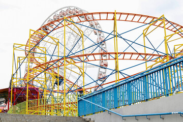 KRAKOW, POLAND - MAY 23, 2023: Ferris wheel and the roller coaster at the amusement park in Krakow,...