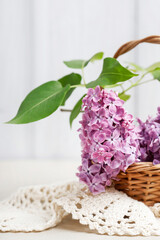 Lilac flowers in wicker basket, copy space.