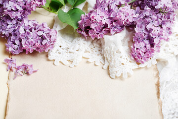 Lilacs and laces on vintage paper background, copy space