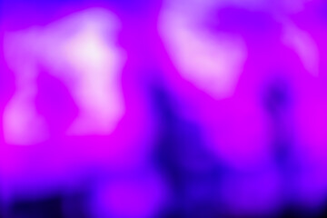 Abstract image with soft undefined shapes of purple and blurry lights like those of a music concert stage.