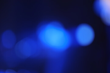 Abstract image with soft undefined shapes of blue color and blurry lights like those of a music...