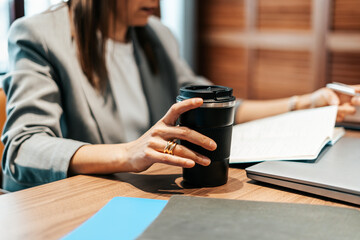 woman working in an office with a thermos flask of coffee