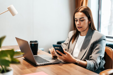 woman in the office using her smartphone