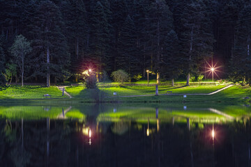 Night photo of the lakeside landscape. Great reflection of water. Unique water park image.