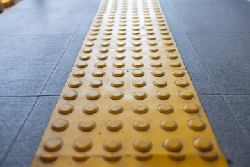 yellow tactile tiles are installed on outdoor pedestrian walkways to provide tactile ground surface...