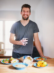 Man, coffee and healthy food in kitchen for portrait with meal for nutrition breakfast, diet and wellness. Happy, male person and eating fruit, vegetable or popcorn for organic snack in the morning