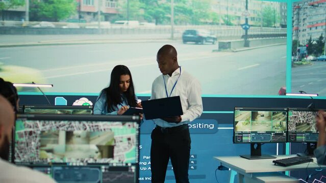 Team leaders reviewing traffic data collected from video surveillance footage, monitoring urban infrastructure by using CCTV cameras system. Government agency works on public safety. Camera B.