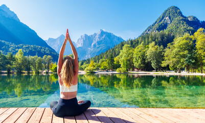Woman doing yoga in beautiful nature with lake and forest- relax, zen, calm