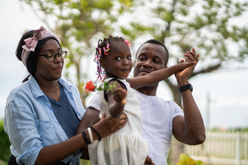 Fototapeta premium Portrait of enjoy happy love black family.play, having fun, daughter, parenthood, care, superhero.african american father and mother with little african girl child smiling moments good time at home